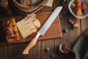 Brotmesser mit edlem Olivenholz Griff, Detailbild auf Holzbrett, Geschenk Geburtstag oder Hochzeit